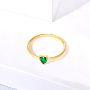 Detailed view of heart-cut green emerald gemstone set in a minimalist gold ring