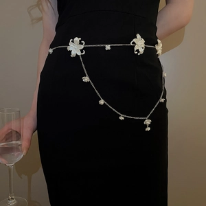 Silver waist chain with white acrylic flowers and pearls worn on a black dress