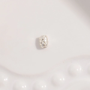 Macro shot of silver barrel spacer bead with elegant diamond quilted texture for jewelry