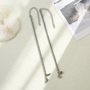 Detail of silver V-link chain bracelets with magnetic heart clasps for couples