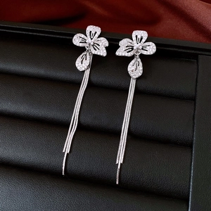 Detail of silver floral drop earrings featuring shimmering tassels and cubic zirconia