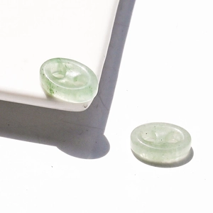 Detailed view of light green natural jade oval stone links with two-hole pig nose design