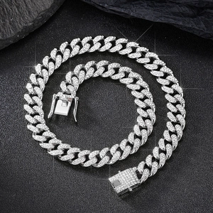 Macro detail of 12mm silver Cuban link chain with encrusted rhinestones on black stone