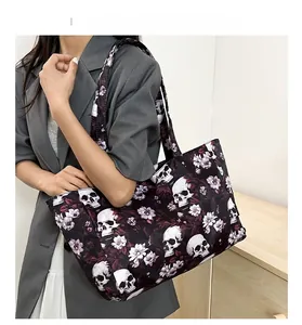 Detailed view of large gothic skull floral tote bag worn on shoulder over grey blazer