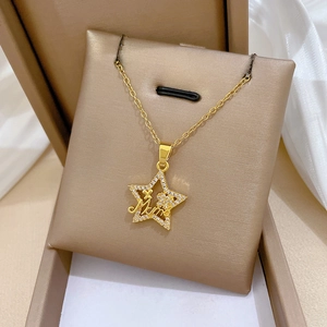 Macro shot of gold star-shaped Mum pendant with sparkling crystals on beige jewelry cushion