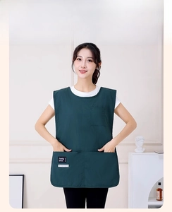 Detail view of dark green waterproof apron vest with large functional pockets for work