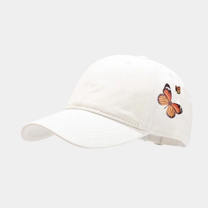 Detailed view of white cotton baseball cap with two delicate butterfly prints on the side