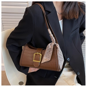 Brown crocodile pattern baguette bag with a silk scarf detail worn with a black blazer