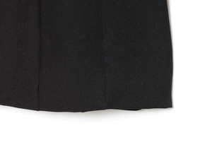 Gros plan des coutures et de la texture du tissu sur l'ourlet de la robe noire