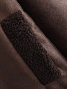 Detailed macro view of dark brown suede texture and plush faux fur lining on jacket