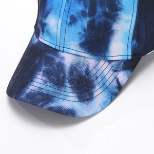 Detailed macro view of blue and white tie-dye cotton baseball cap brim with stitching