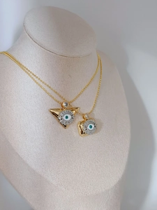 Detail of vintage gold evil eye necklaces in triangle and square shapes on neck model