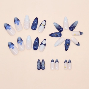 Detailed view of deep blue lily press-on nails with 3D gold beads and almond shape