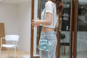 Detail view of light blue transparent jelly bag with matching inner pouch and slim strap