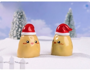 Close-up of two cute Christmas potato dolls with red hats in a snowy DIY landscape