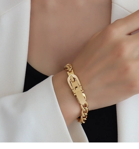 Detail of 18k gold plated chunky U-link chain bracelet worn with a white blazer