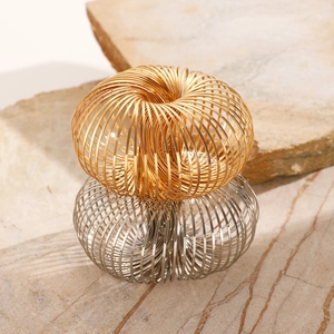 Detail of twisted spiral metal bracelets in gold and silver on a textured stone surface