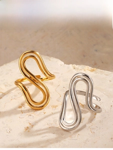 Detailed view of intertwined S-curve stainless steel rings in gold and silver finish