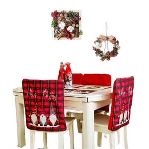 Christmas chair covers with red plaid gnomes and Merry Christmas text in a festive dining room