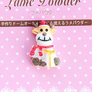 Macro view of cartoon reindeer resin cabochon with glitter details and 2x3cm size marker