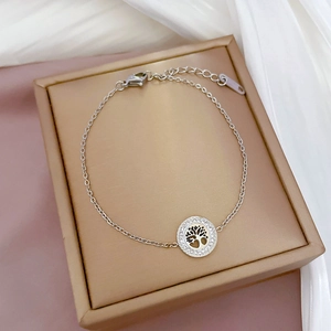 Detail of silver tree of life bracelet with rhinestones on a silk background