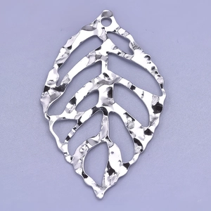 Macro shot of silver 304 stainless steel leaf pendant with hammered metal texture