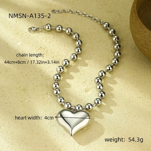 Macro view of polished silver bead chain necklace featuring a large 3D heart pendant