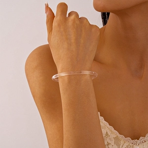 Gros plan d'un bracelet rond minimaliste en acrylique transparent montrant une texture lisse