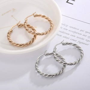 Detail of twisted rope texture on large gold and silver hoop earrings for women