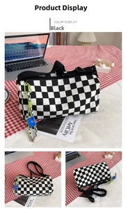 Detail of checkered canvas bag with neon green charm and black strap in office setting