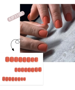 Detail of matte coral orange short square press on nails set with professional finish