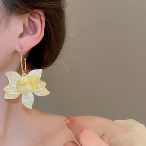 Gros plan détaillé de la grande boucle d'oreille fleur en résine sur un mannequin