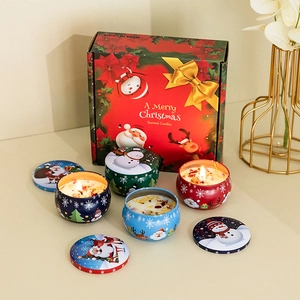 Close-up of scented candle set with dried flower petals and festive Christmas gift box