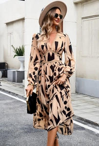 Detail of V-neck printed long sleeve dress with waist tie and black geometric patterns
