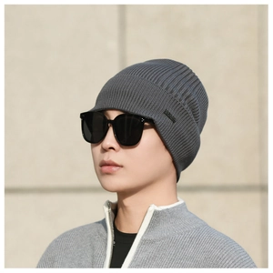 Detail of dark grey ribbed knit beanie for men with small side logo patch