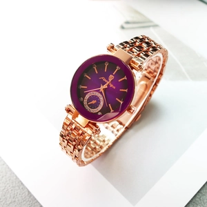 Vue macro d'une montre à quartz or rose avec cadran dégradé violet et strass brillants
