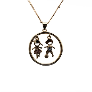 Golden necklace with round pendant featuring a boy kicking a ball and girl with gemstones