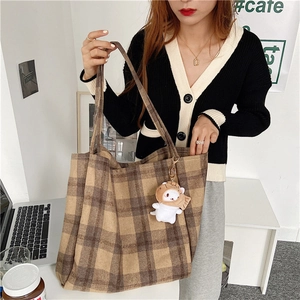 Detail of vintage plaid tote bag in thick wool fabric with cute cat plush pendant charm