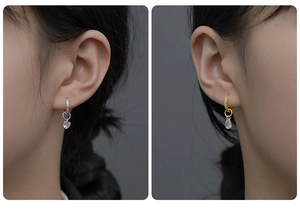 Close-up of S925 silver hoop earrings with heart and teardrop crystal pendants in gold and silver
