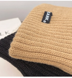 Detailed close-up of ribbed knit texture on khaki and black sports headbands with RANK label
