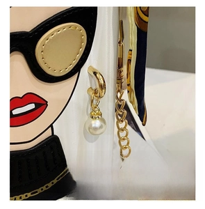 Detail showing white leather bag with artistic portrait print, pearls and chain strap