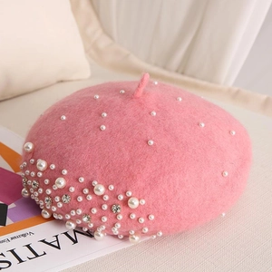 Detailed close-up of pink wool beret featuring elegant pearls and sparkling rhinestones