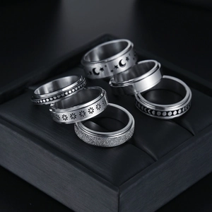 Set of 6 silver spinner rings with moon and star patterns in a black leather box