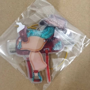 Detail view of acrylic western saddle keychain with colorful painted patterns and gold cord