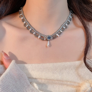 Detailed view of vintage lace choker featuring blue gemstone and teardrop pearl pendant