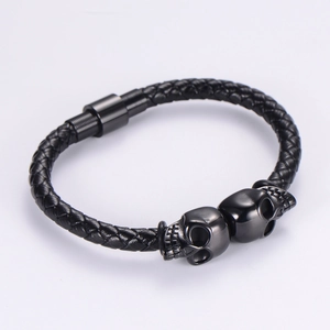 Punk black braided leather bracelet with twin metal skulls and magnetic clasp