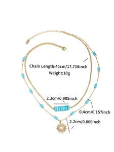 Detailed view of layered 14K gold necklace with turquoise beads and heart sun pendant