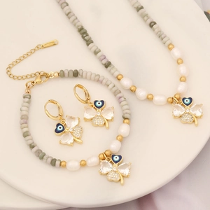 Jewelry set with pearl necklace, bracelet and clover evil eye earrings on white plate