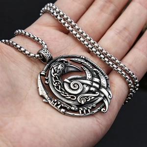 Silver Viking raven pendant necklace with Nordic knot design held in hand