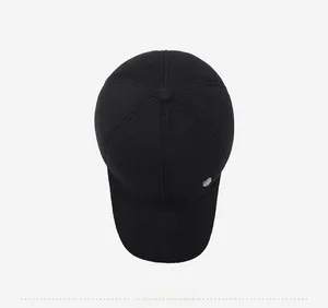 Top view of a black winter baseball cap featuring textured wool fabric and a metal badge